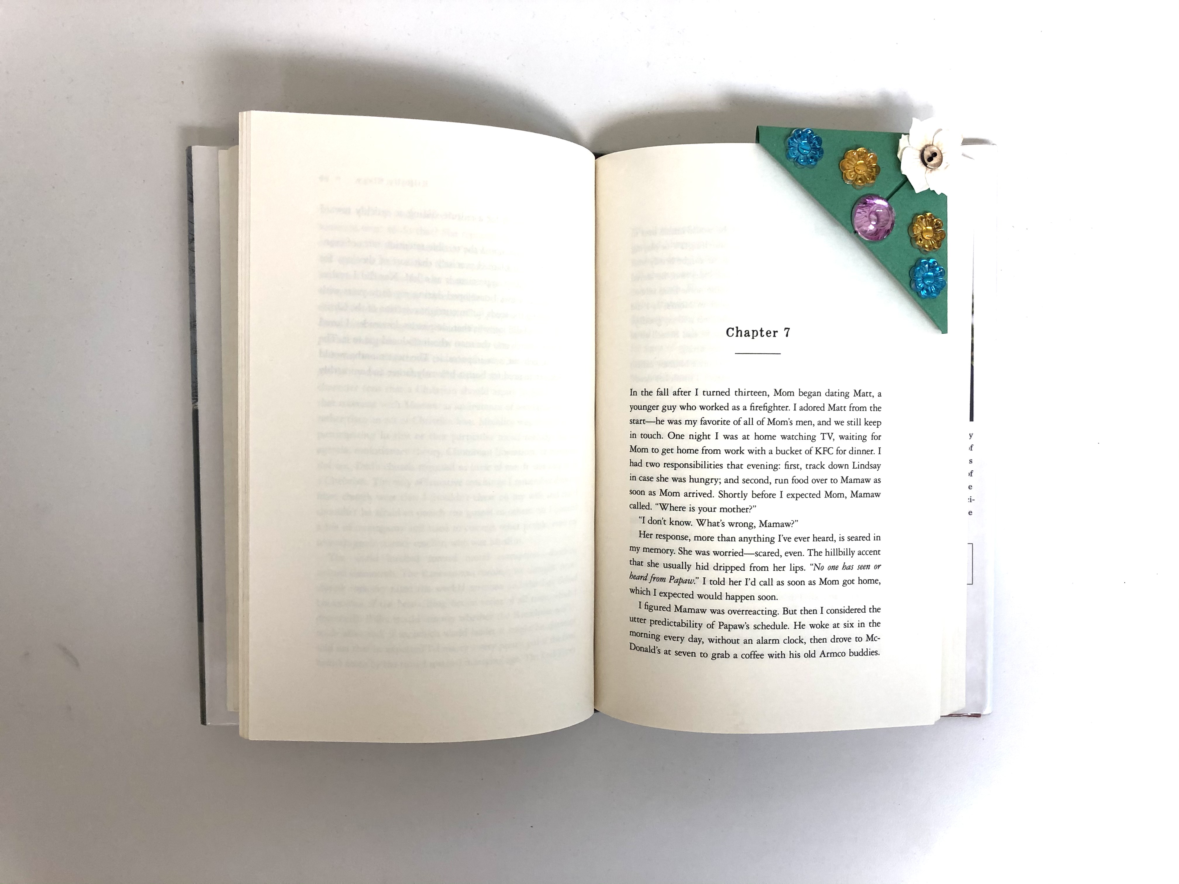 An origami bookmark in the shape of a tree marks a book page.